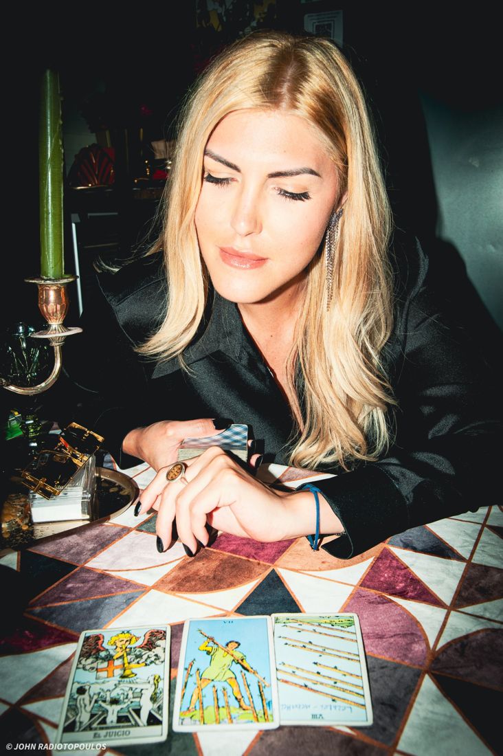 Mia reading three tarot cards by candlelight